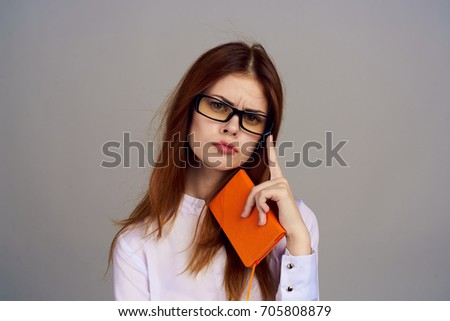 Woman accountant with a notebook on a gray background, finance                               