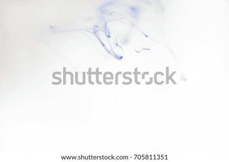 Blue ink dissolving in water resembling smoke