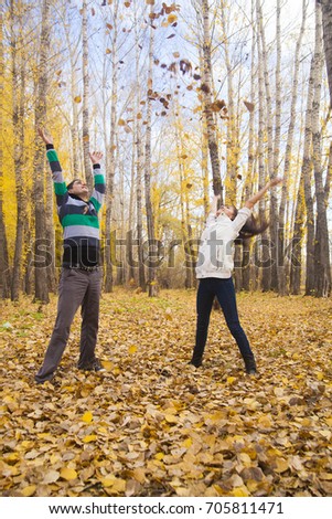 Young adult latin hispanic happy couple throwing up autumn leaves in the air or heaven. Empty Copy Space for inscription. Idea of active lifestyle. autumn time season.  hand's up