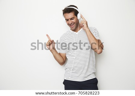 Guy loving the music from his headphones and dancing