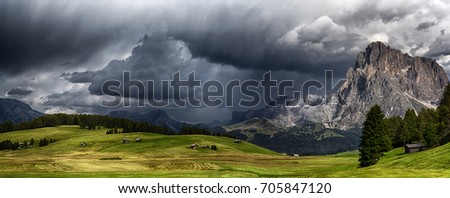 storm over the mountains Dolomiti in the summer season with green meadow illuminated of the Sun Royalty-Free Stock Photo #705847120