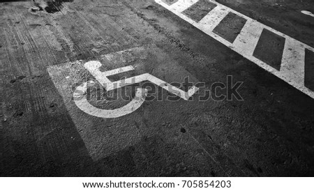 Disabled sign in car parking area  - black and white 
