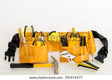 set of tools in toolbelt tape measure nippers djustable wrench pliers hammer cutter on  white board Royalty-Free Stock Photo #705919477