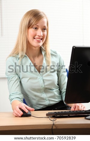Beautiful blonde woman busy at office computer