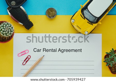 Car rental agreement document contract with key, coins and car model, top view in flatlay