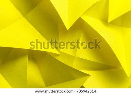 Yellow paper folded in geometric shapes, abstract background