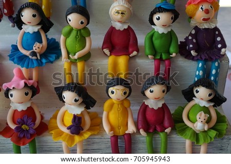 Colorful Doll and Family Dolls sitting on white wooden chair for decorate in house.