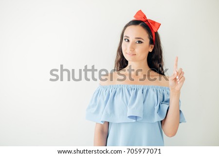Portrait of cheerful young woman showing copyspace, visual imaginary or something, or pressing virual button
