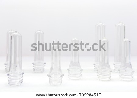 group of transparent plastic PET preforms are displayed on the shelf in white background. industrial concept. selective focus.