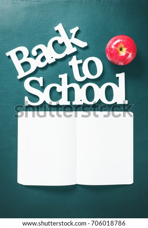Volume White Letters Back To School with Apple and Notebook Concept Stationery on Green Background Copy Space Top View Flat Lay
