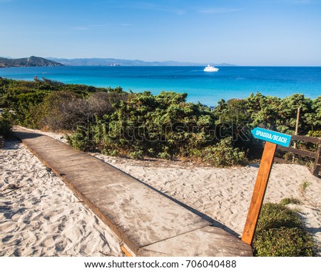 a sign leading to a beach - sardinia, italy