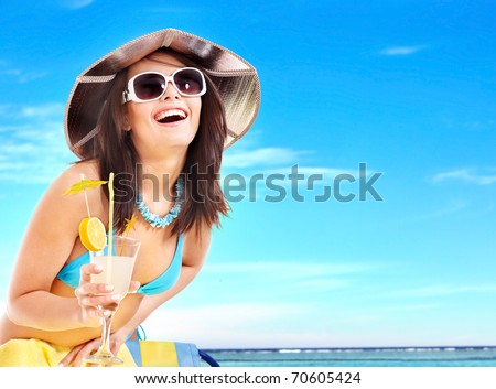 Girl in bikini drink juice through a straw.