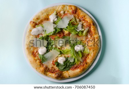 Caesar pizza on a white plate on a blue background