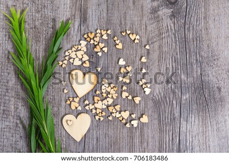 Heart shape and green foliage on wood texture background, Studio shot on wooden background.