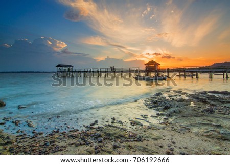 Sunset at beach with fisherman boat parking and jetty . Mersing Johor. This image may contain noise ,blurry clouds due to long exposure, soft focus and poor lighting