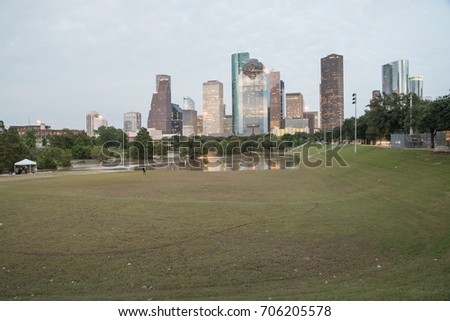 Reflection of Downtown Houston skyscrapers on a pond of overflow water from Bayou River to Eleanor Park after Harvey tropical storm. Heavy rain of hurricane Harvey caused many flooded areas in Houston