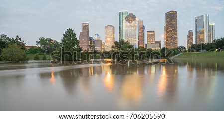 Panorama reflection of Downtown Houston skyscrapers on a pond of overflow water from Bayou River to Eleanor Park after Harvey tropical storm. Heavy rain of hurricane Harvey caused many flooded areas