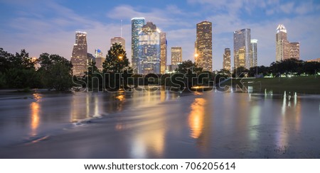 Panorama reflection of Downtown Houston skyscrapers on a pond of overflow water from Bayou River to Eleanor Park after Harvey tropical storm. Heavy rain of hurricane Harvey caused many flooded areas
