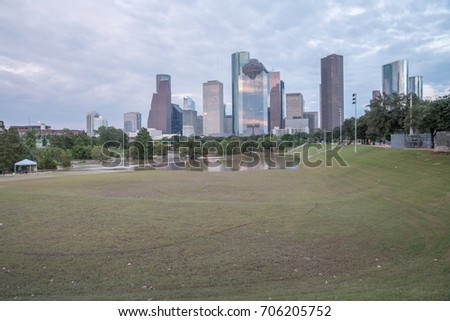 Reflection of Downtown Houston skyscrapers on a pond of overflow water from Bayou River to Eleanor Park after Harvey tropical storm. Heavy rain of hurricane Harvey caused many flooded areas in Houston