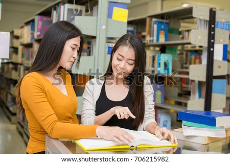 Woman in the foreground is reading a books. Young Asian Woman are reading in the modern library with Happy emotion. People with Education concept.