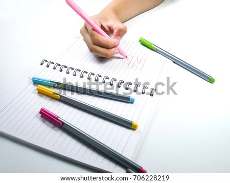  notebook and magic pens in a hand.on white background .