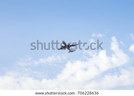 Picture of an airplane flying above the clouds in the blue sky