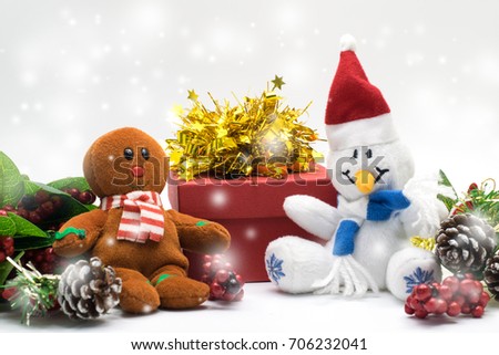 ginger bread cookie and snowman plush toy doll with gift box, red berry and cone pines on red background with copy space for text, Christmas and new year concept with snow