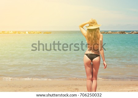 Woman in straw hat at sandy beach