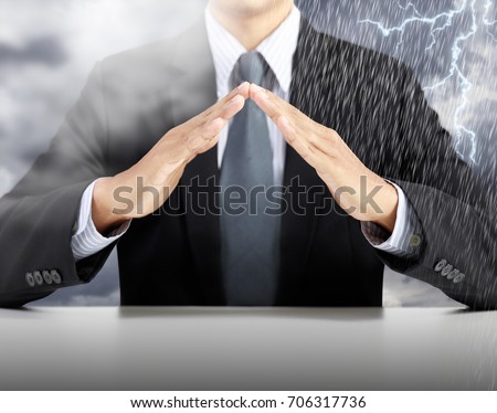 businessman hand cover with rain and storm background, insurance concept
