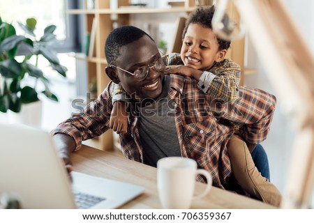 father spending time with son and working with laptop Royalty-Free Stock Photo #706359367