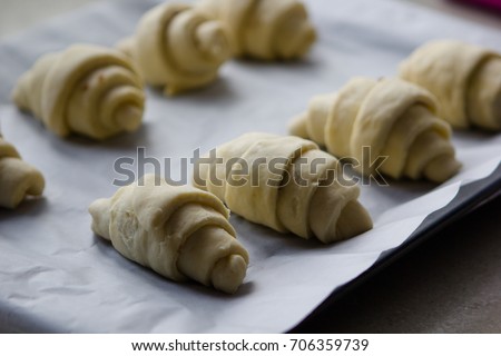 traditional St martin's croissants being prepared, croissants rolled lying on parchment paper
