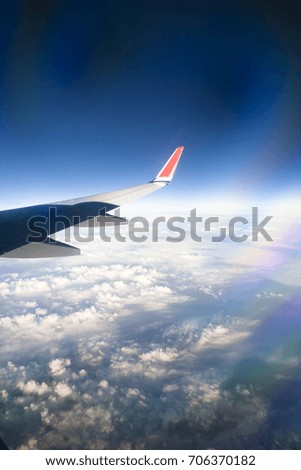 View from airplane window with blue sky and white clouds