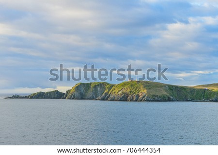 A Landscape view of the  Cape Horn headland, showing the Lighthouse. Taken from a passing Cruise ship, on route to Antarctica. Royalty-Free Stock Photo #706444354