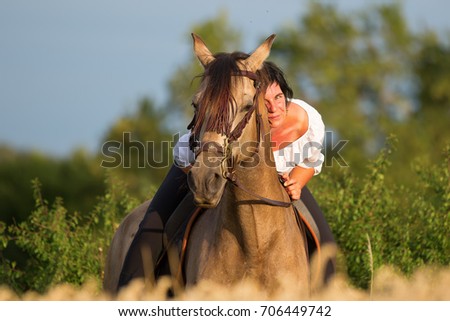 portrait picture of a mature woman on an Andalusian horse