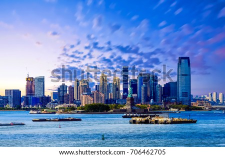 The skyline of Jersey City, New Jersey from New York Harbor with the Statue of Liberty in the foreground Royalty-Free Stock Photo #706462705