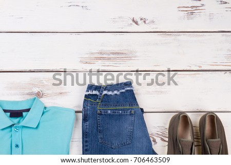 T-shirt, jeans, sneakers, collection buy. Summer casual outfit on white wooden surface.