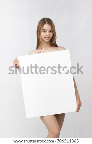 White banner .Teenager girl hold white blank paper. Young smiling woman show blank board. Close up female model portrait isolated on white background.