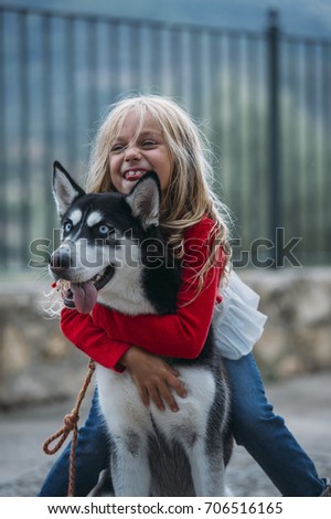 Beautiful blonde girl poses with pet Siberian Husky