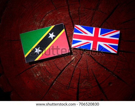 Saint Kitts and Nevis flag with British flag on a tree stump isolated