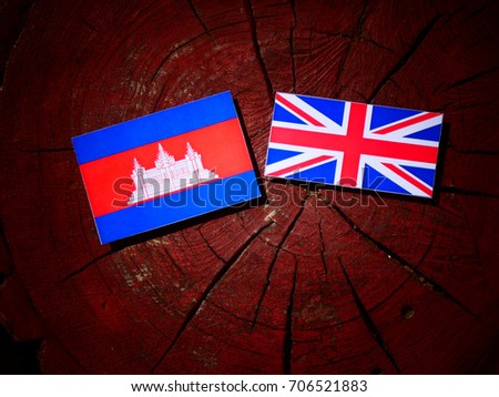 Cambodian flag with British flag on a tree stump isolated