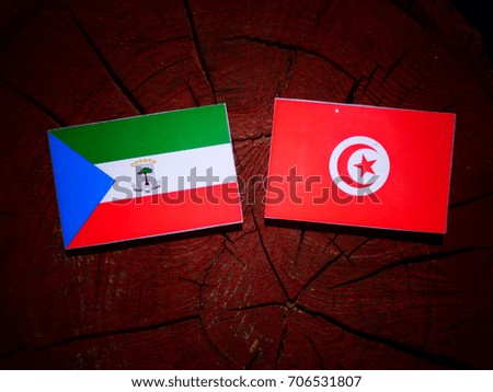 Equatorial Guinea flag with Tunisian flag on a tree stump isolated