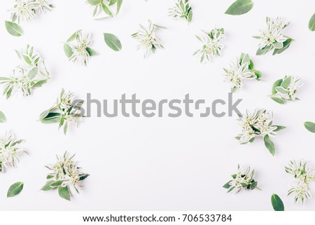 Green flowers and leaves with frame for text in the middle on a white table