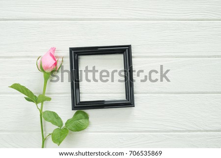 Black  square frame photo with pink rose view from above