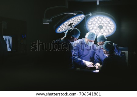 Medical team performing surgery. Group of surgeons in hospital operation theater. Royalty-Free Stock Photo #706541881