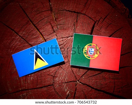 Saint Lucia flag with Portuguese flag on a tree stump isolated