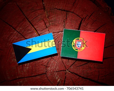 Bahamas flag with Portuguese flag on a tree stump isolated