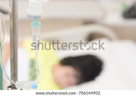 IV drip and line with blur background of child patient in hospital bed