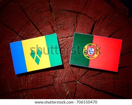 Saint Vincent and the Grenadines flag with Portuguese flag on a tree stump isolated