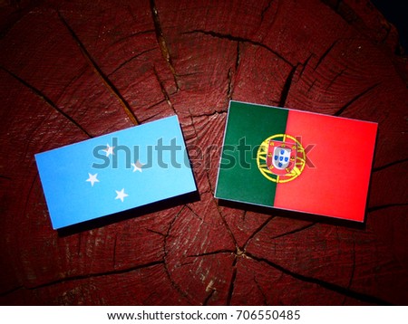Micronesian flag with Portuguese flag on a tree stump isolated