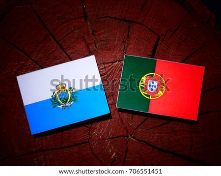 San Marino flag with Portuguese flag on a tree stump isolated